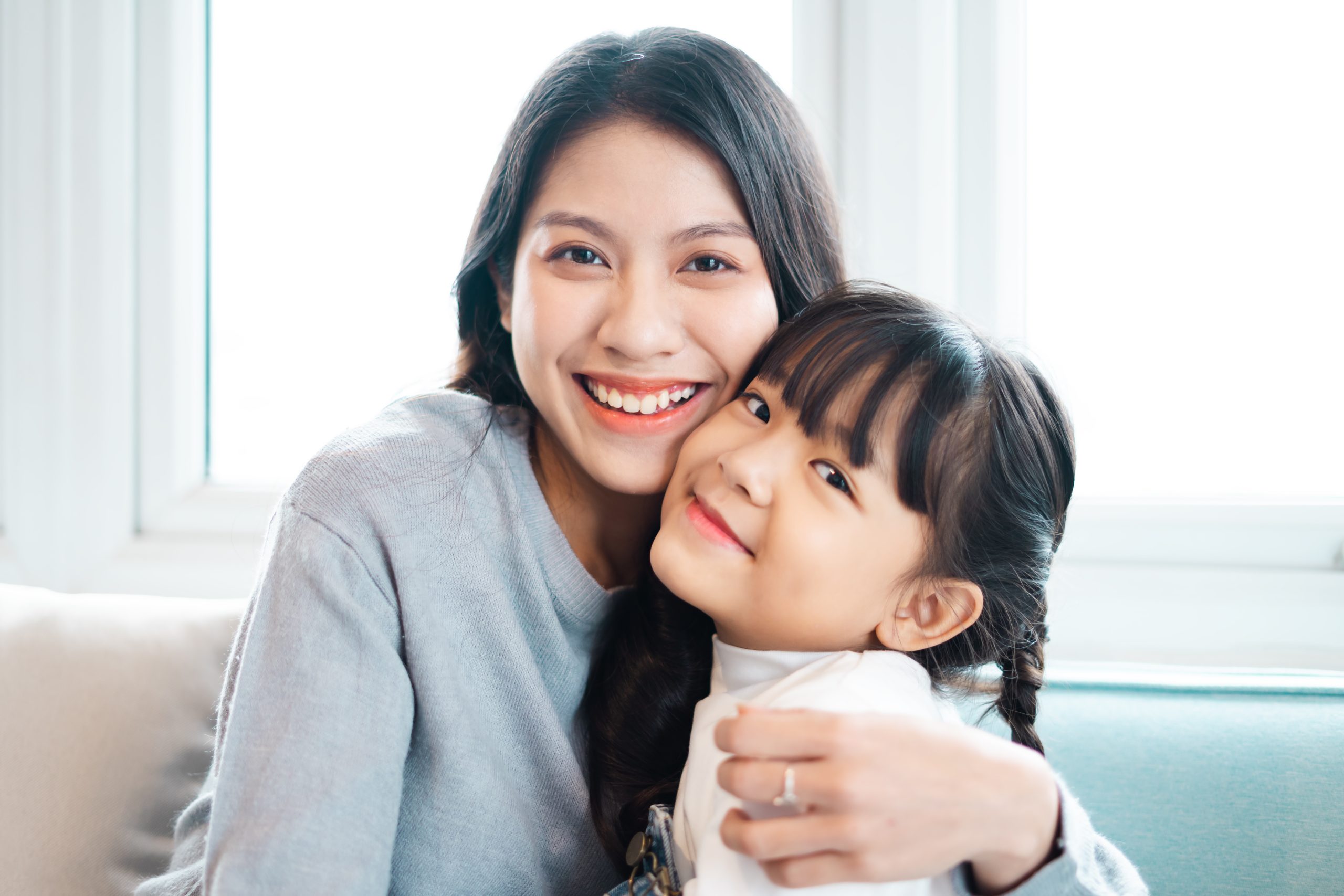 image of mother and daughter cuddling on the sofa